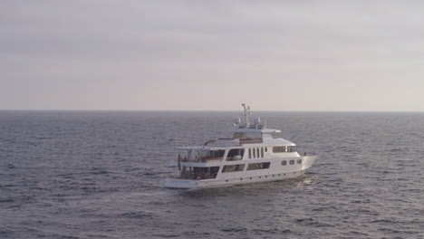 Arcing-drone-shot-of-a-luxury-yacht-sailing-through-the-open-ocean