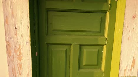 distancing shoot from improvised built house with green door, located at river banks, suburbs and living near the water concept