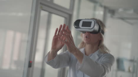 a blonde, middle aged female doctor navigates through data with vr glasses