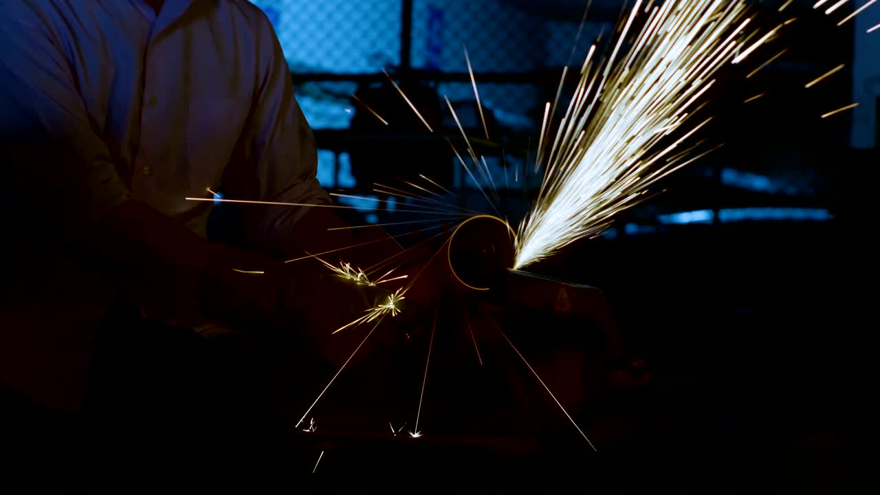 Young engineering  is cutting metal with angle grinder in workshop