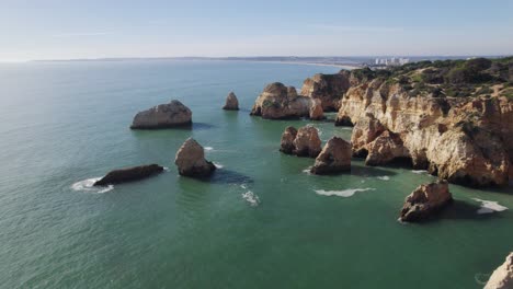 pilares marinos junto al acantilado de la costa de portimão, algarve, portugal - aero