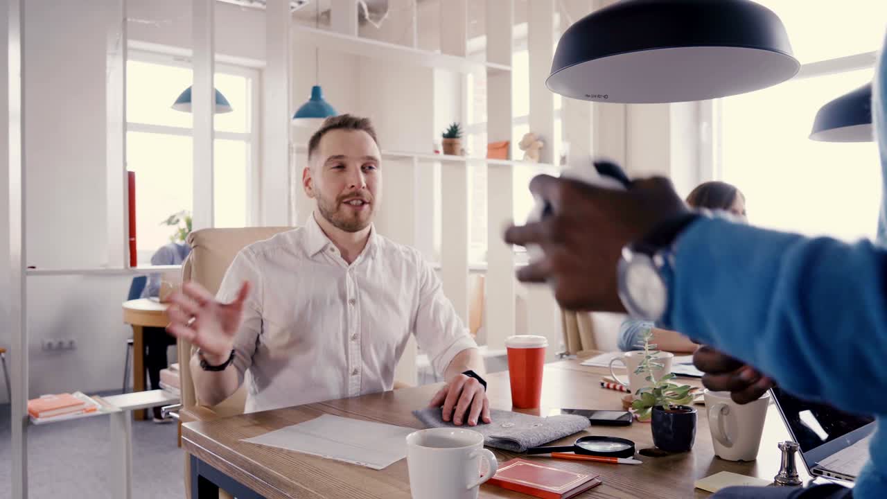 African American employee talks to friendly CEO. Mixed race business people smile, work in healthy office atmosphere 4K
