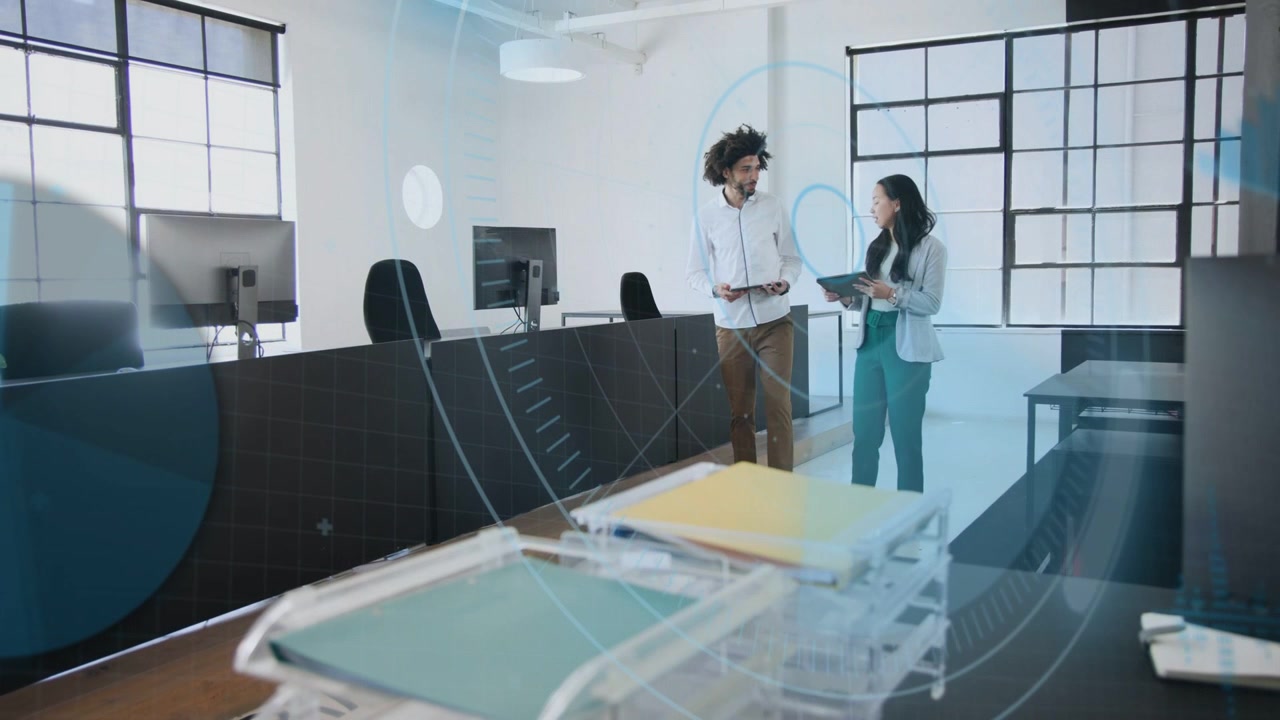 Two coworkers entering from right, consulting tablets, reviewing docs in office under blue overlay