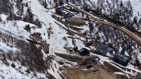 high-resolution aerial drone footage of a snow-covered mountain landscape, featuring rugged terrain, forested slopes, and a serene winter atmosphere.