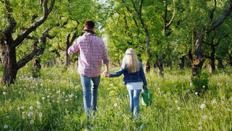 Ein-Bauer-Mit-Einer-Jüngeren-Schwester-Geht-Durch-Den-Apfelgarten-Und-Trägt-Sense-Und-Gießkanne