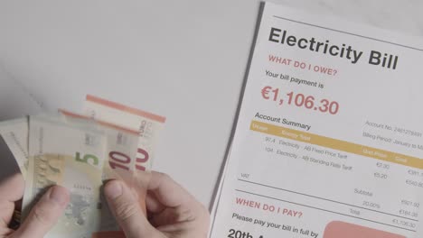 hand counting currency in euros to pay for european electricity energy bill 2