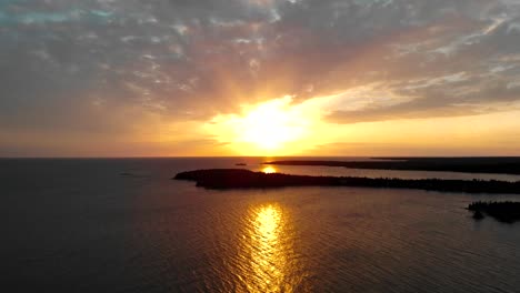 Toma-Aérea-Que-Avanza-Hacia-La-Puesta-De-Sol-Y-Las-Nubes-Sobre-El-Océano-Y-Las-Islas