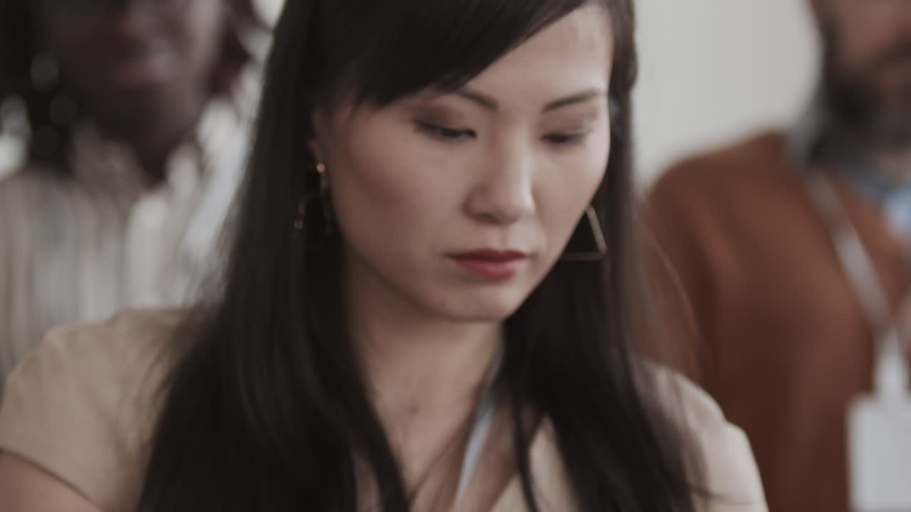 Asian Woman Taking Notes and Nodding