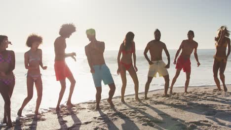 friends dancing side by side at beach