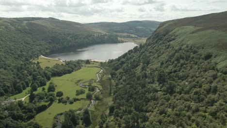 wicklow, ireland - a picturesque lough tay, surrounded by lush vegetation and majestic mountains - aerial drone shot