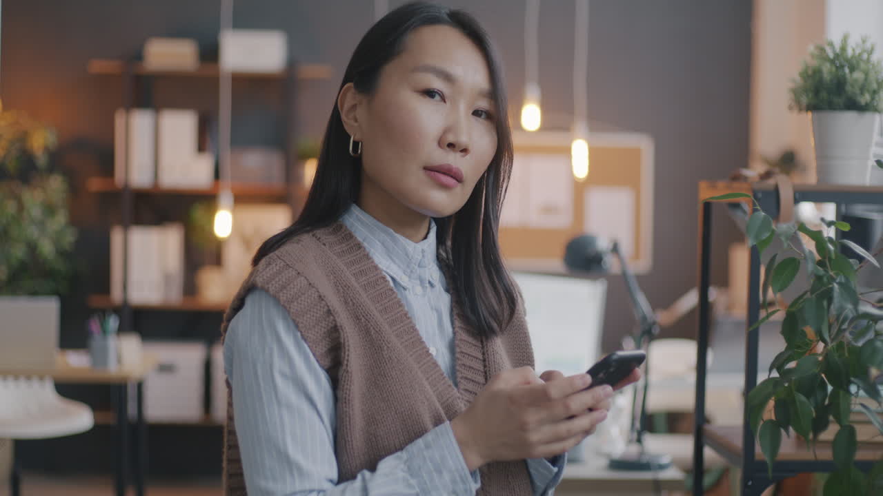 Woman using smartphone in a home office