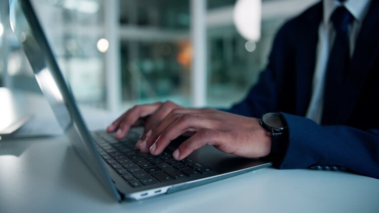 Geschäftsmann tippt auf einem Laptop in einer Büroumgebung