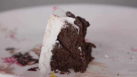 close-up of a spoon cutting into a creamy cake with red sprinkles