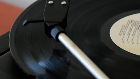 pickup arm lifting up from spinning vinyl record disc