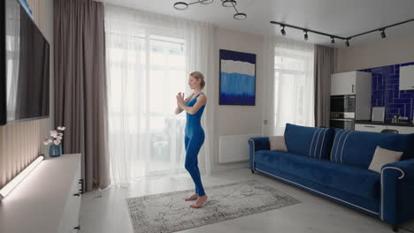 home yoga workout on the carpet in the afternoon near the sofa and tv in the living room. morning exercises and yoga class. complex yoga exercises for balance and endurance