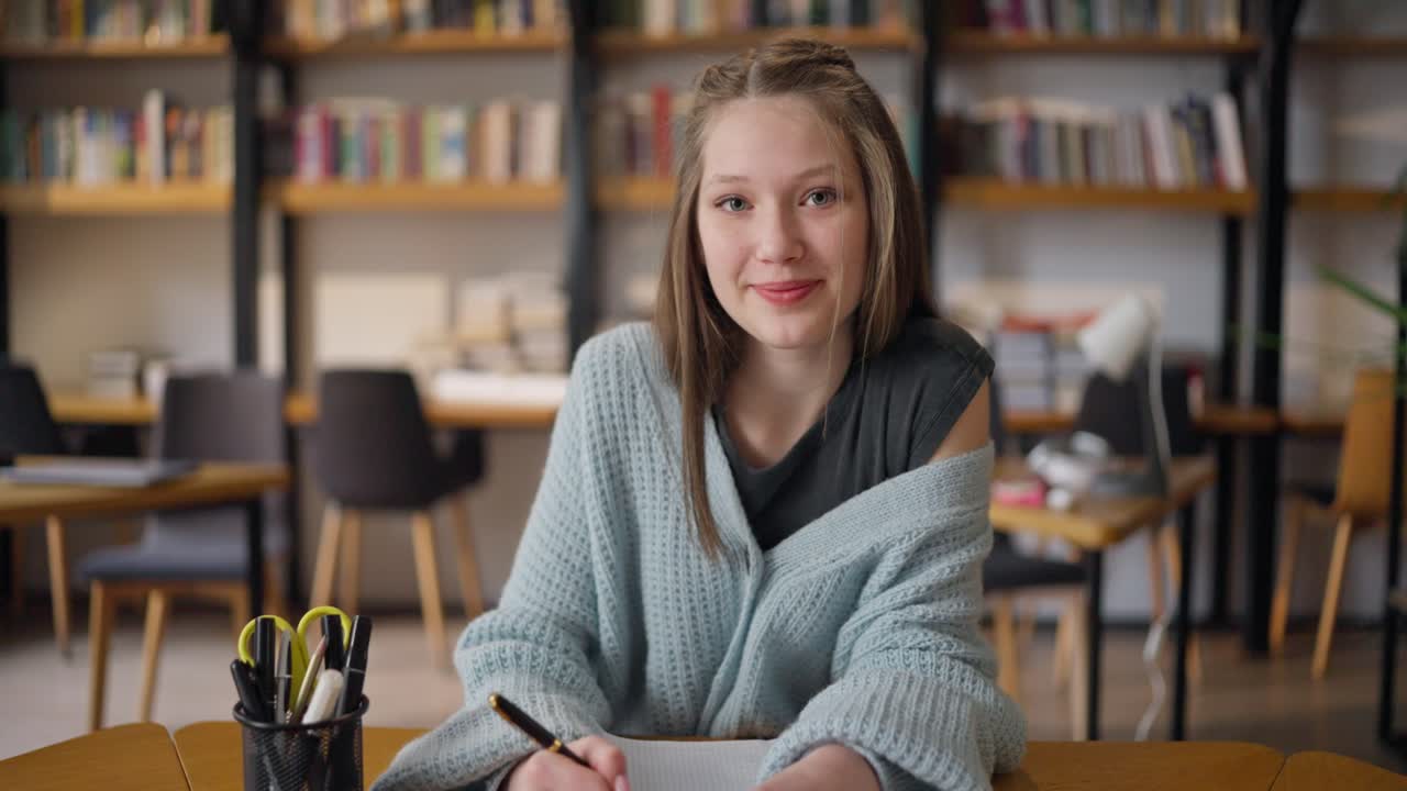 Ragazza adolescente che studia in biblioteca