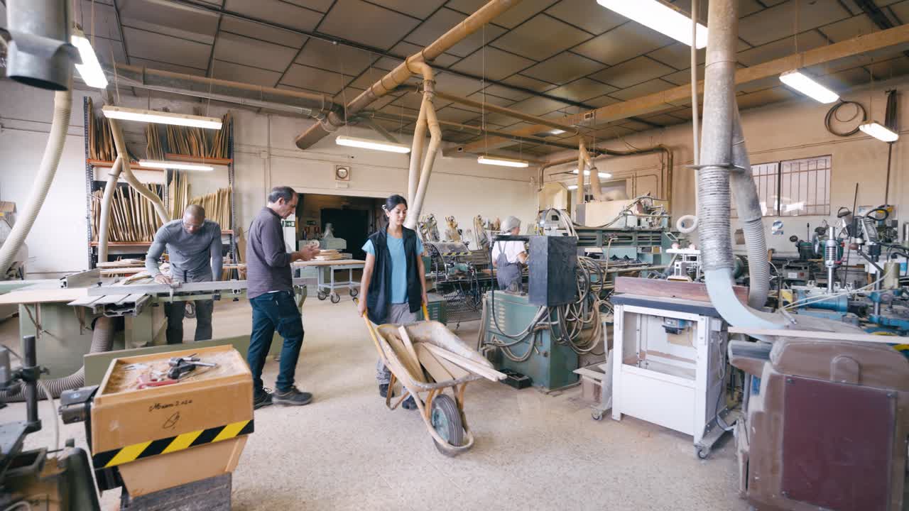 Diverse groep ambachtslieden werkzaam in een drukke houtbewerkingswerkplaats