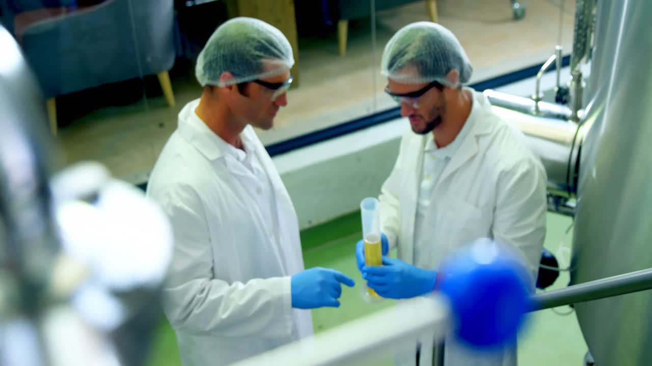 Two brewers discussing with each other at brewery factory 4k