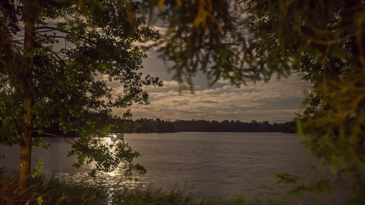 Lua brilhando enquanto atravessa a paisagem celeste e reflete na água do lago, timelapse de fusão
