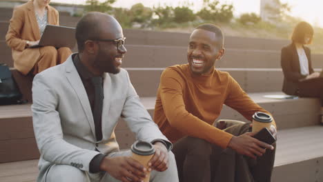 african american businessmen chatting over coffee outdoors