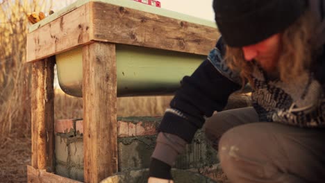 The-Man-is-Applying-Cement-to-Secure-the-Bricks-Beneath-the-Homemade-Hot-Tub---Close-Up