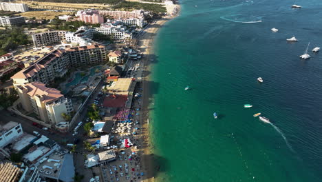 Drone-flying-backwards-along-the-coastline-of-Cabo-San-lucas,-in-sunny-Mexico