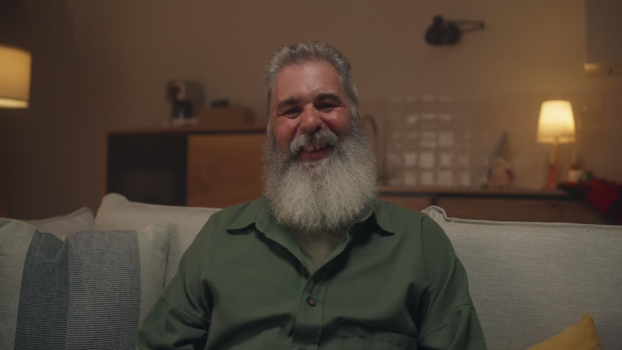 Portrait of a man with a beard sitting on a couch