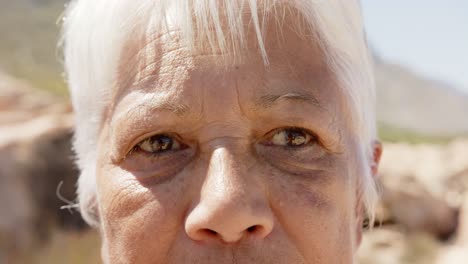 Portrait-of-happy-senior-biracial-woman-in-mountains,-in-slow-motion