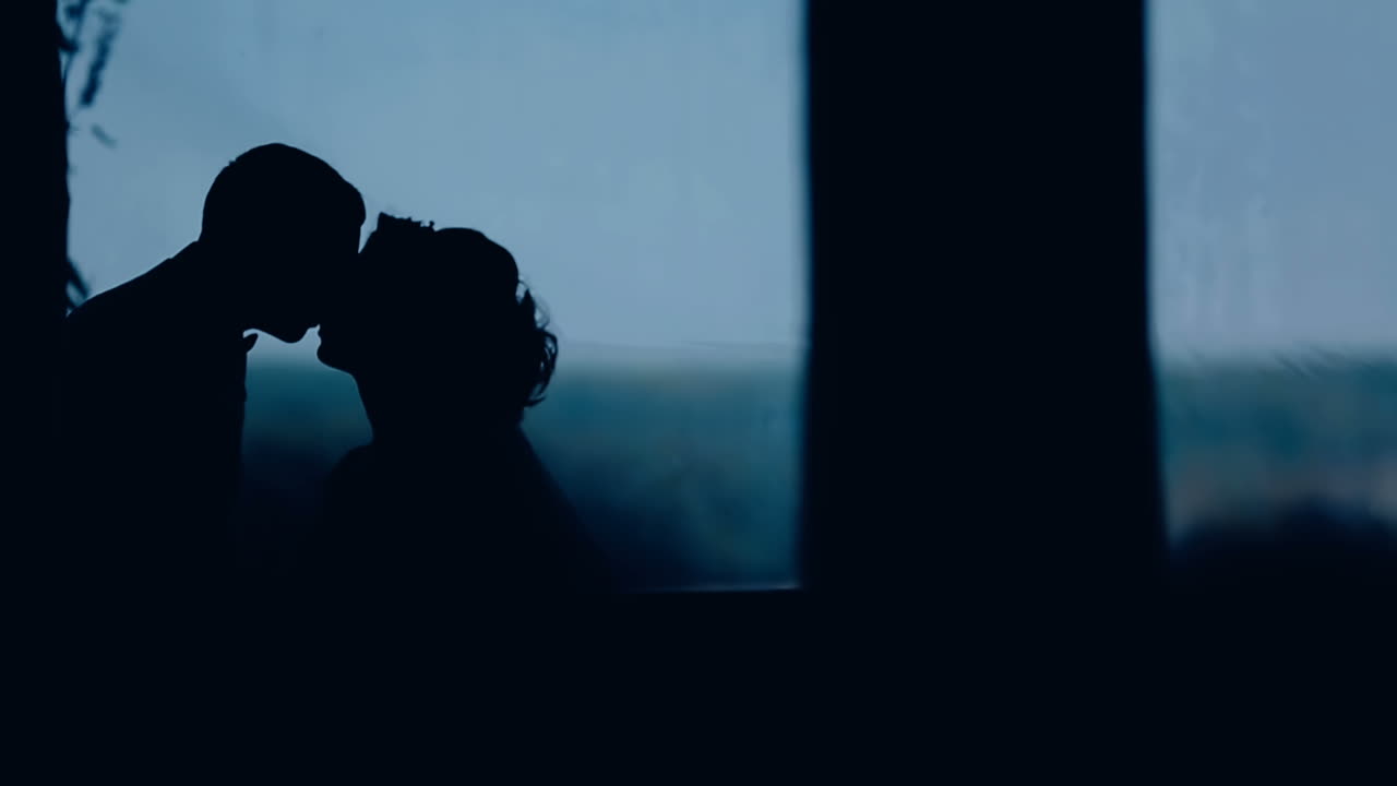 Silhouette of wedding kiss. Shape of bride and groom at sunrset time