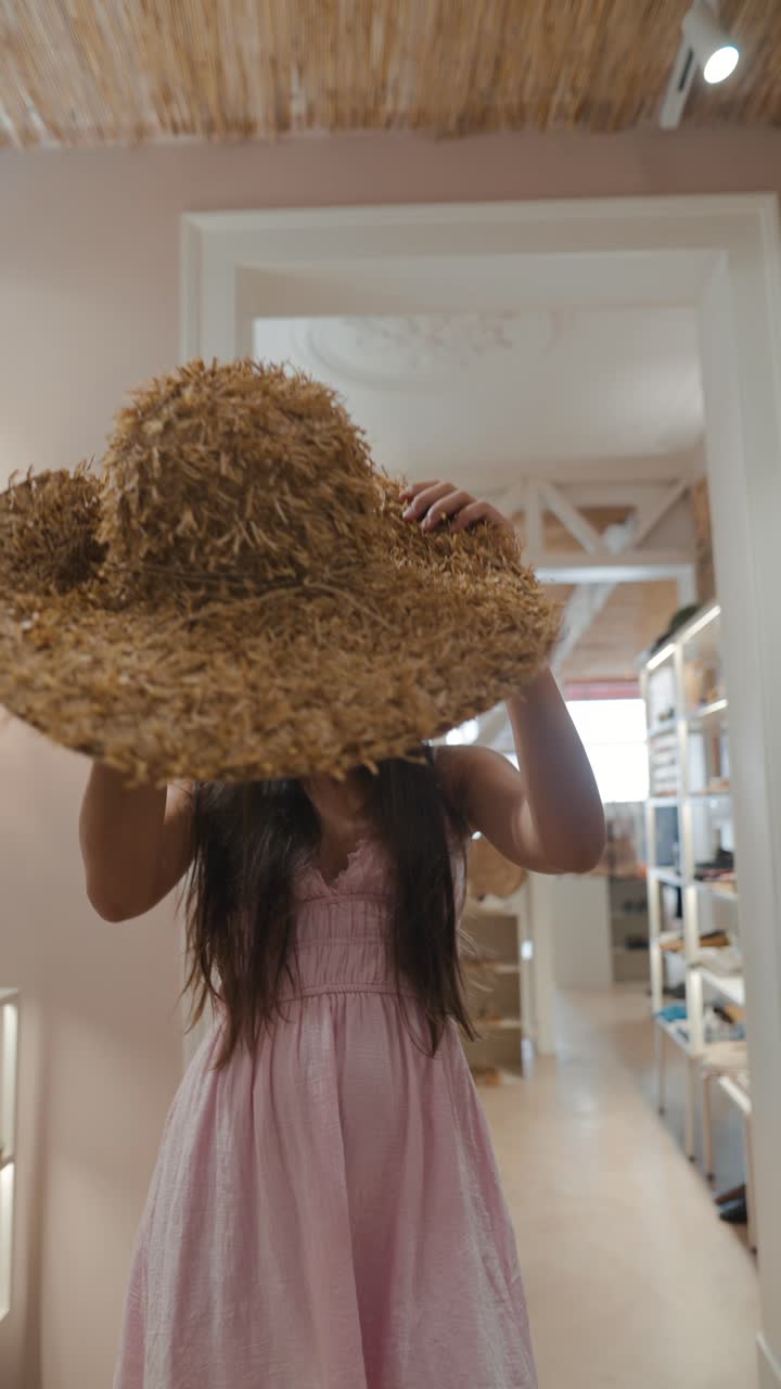 Woman holding straw hat in retail store