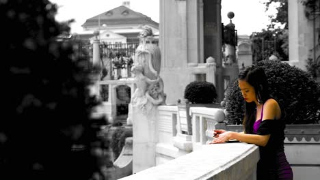 Woman-in-vibrant-dress-stands-thoughtfully-at-Stadtpark,-Vienna,-selective-color,-daytime,-statue-background,-tranquil