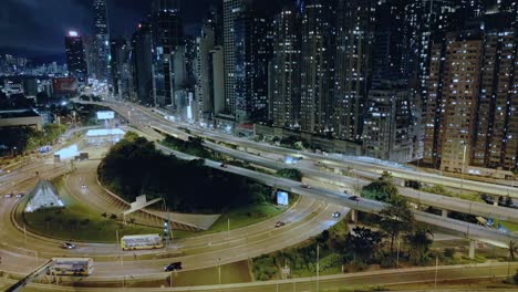 Vista-Aérea-Sobre-Las-Carreteras-Y-Los-Rascacielos-Del-Distrito-Central-En-El-Frente-Del-Puerto-En-La-Isla-De-Hong-Kong-Por-La-Noche,-Hong-Kong,-China