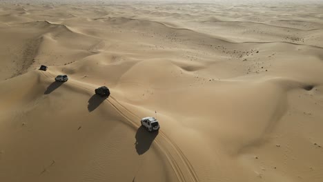 4k:-Drone-Rastreando-Al-Grupo-De-4x4-Durante-El-Safari-Por-El-Desierto-En-El-Desierto-De-Al-Qudra-De-Dubai,-Emiratos-árabes-Unidos