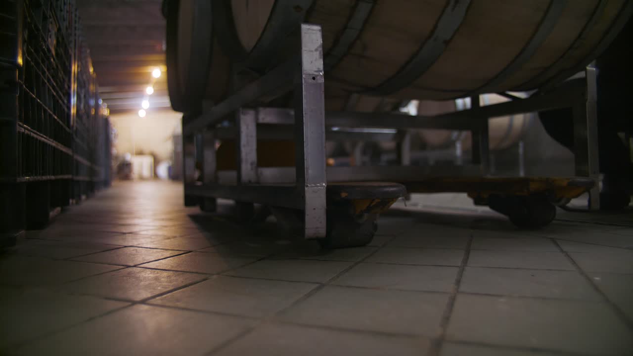 Wine barrels are carted around in a cellar in this stunning 4K clip