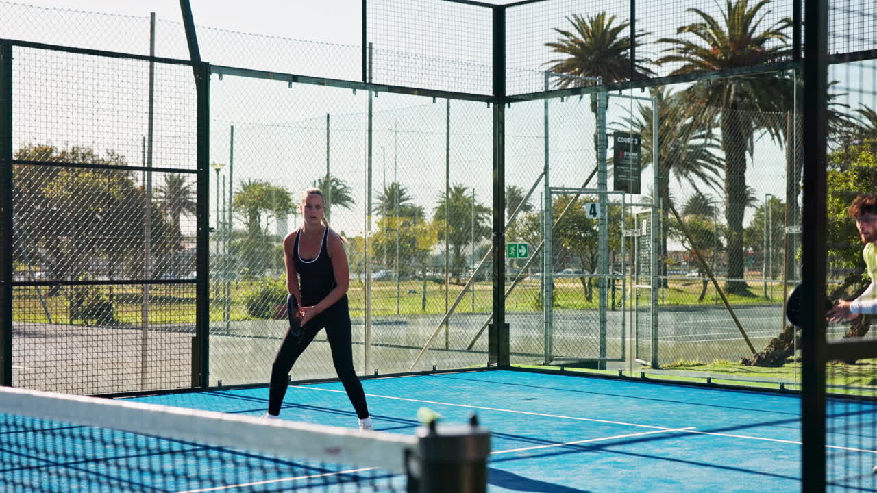 Mann und Frau spielen Padel-Tennis auf einem Außenplatz