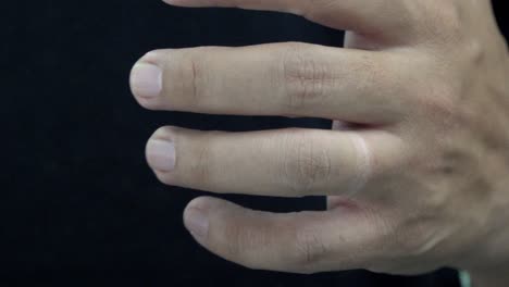 closeup of the hands of a man removing his wedding band from his ring finger and putting it back before clenching his fist