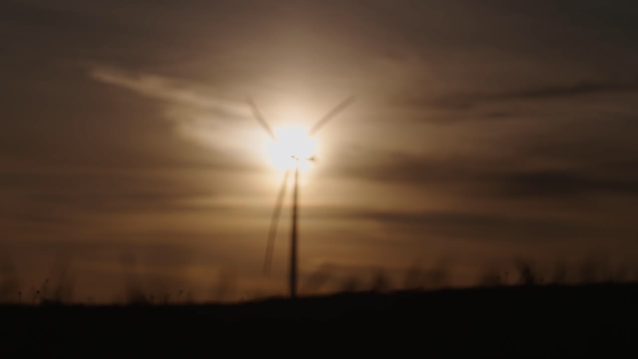 Sunset Silhouettes of Grass and Wind Turbines
