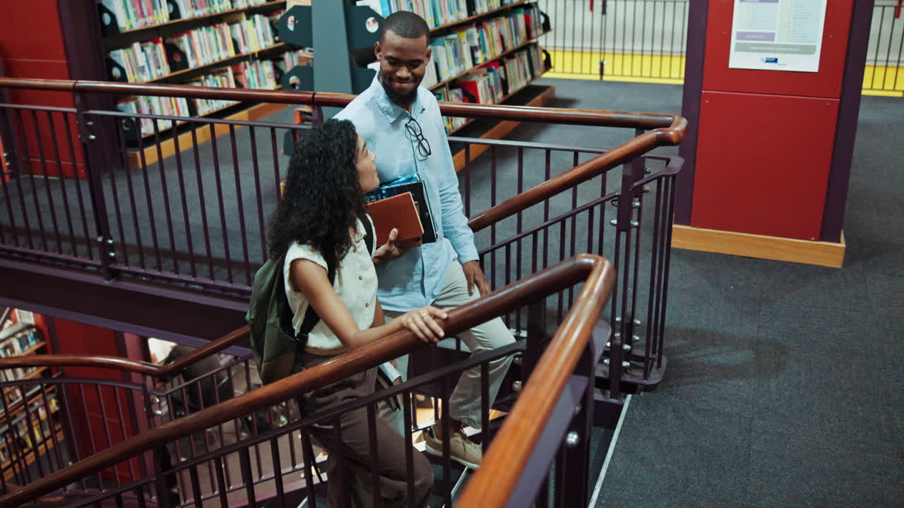 Diverse Students Walking Up a Spiral Staircase in a Modern Library