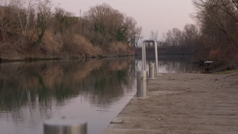 ladder on pier over river at dusk