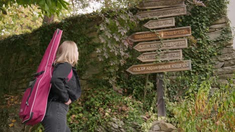 Female-musician-traveller-reads-information-direction-Bulgarian-village