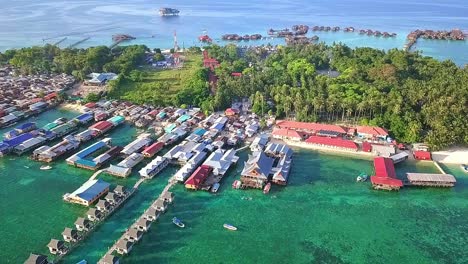 Aerial-flight-over-local-village-and-ocean-in-Malaysia,-long-shot-perspective-moving-away-in-slow-motion