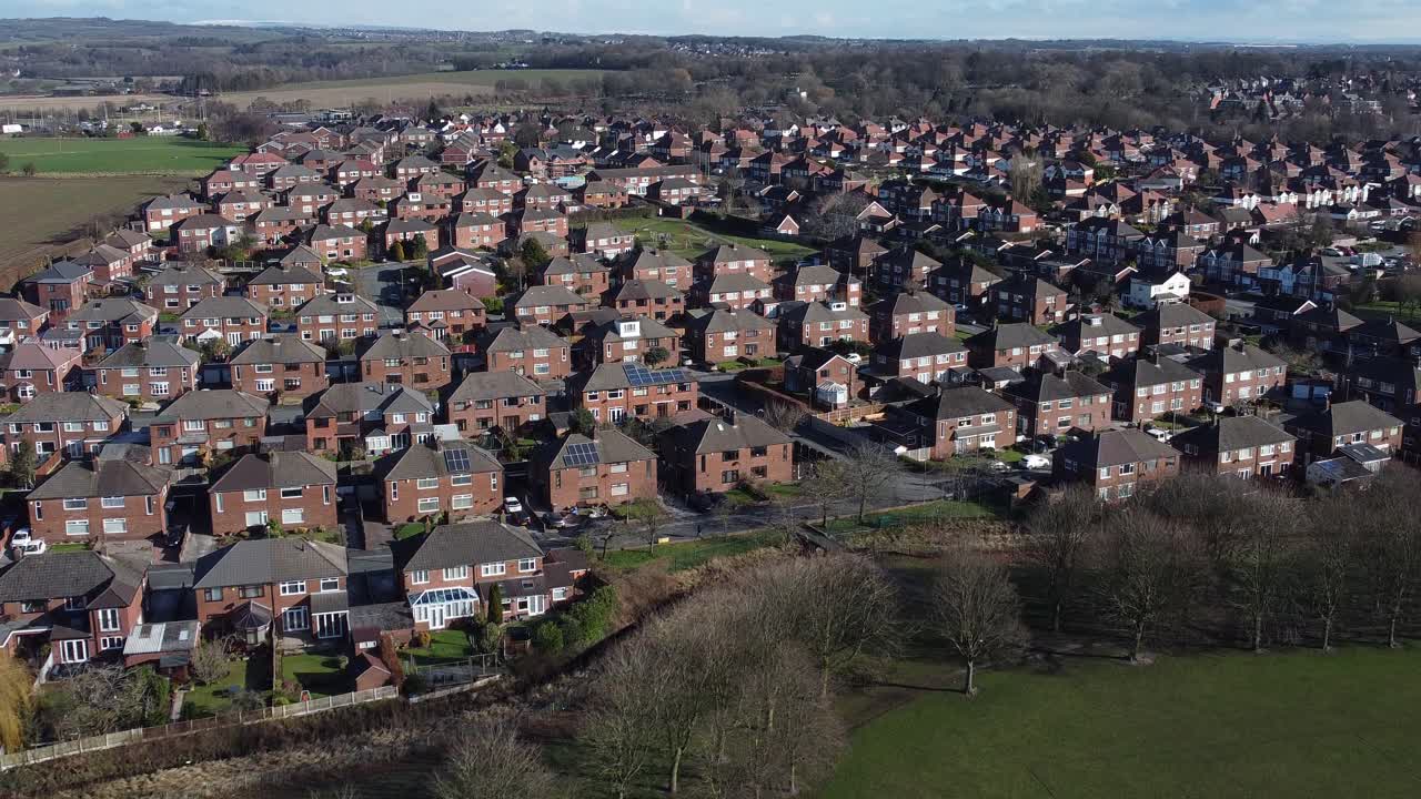 típico pueblo suburbano barrio residencial londres casa adosada tejados vista aérea dolly hacia la derecha