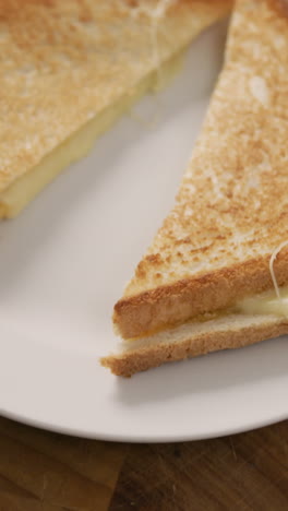 video de sándwich de pan blanco con queso recién preparado en un plato blanco