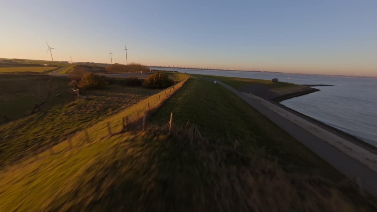Dutch landscape next to the Delta works during sunset. Fast shot above a green dyke