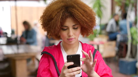 Nervöse-Junge-Frau-Mit-Rotem-Afro,-Die-Ihr-Telefon-Benutzt