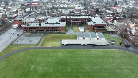 Aerial-of-urban-American-school-building-and-athletic-track-and-field-in-city-in-USA