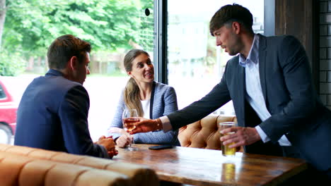 group of business colleagues meeting for drinks and socializing in bar after work