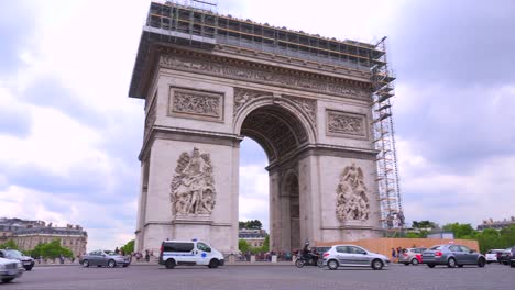 una ambulancia o un vehículo de emergencia circula alrededor del arco del triunfo en parís francia