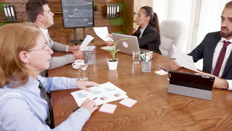 colleagues passing charts to each other in the conference room