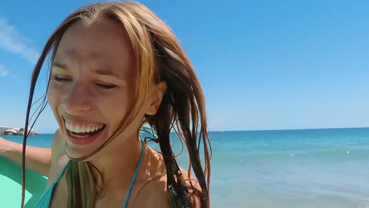 해변에서 서프보드와 함께 달리는 여자